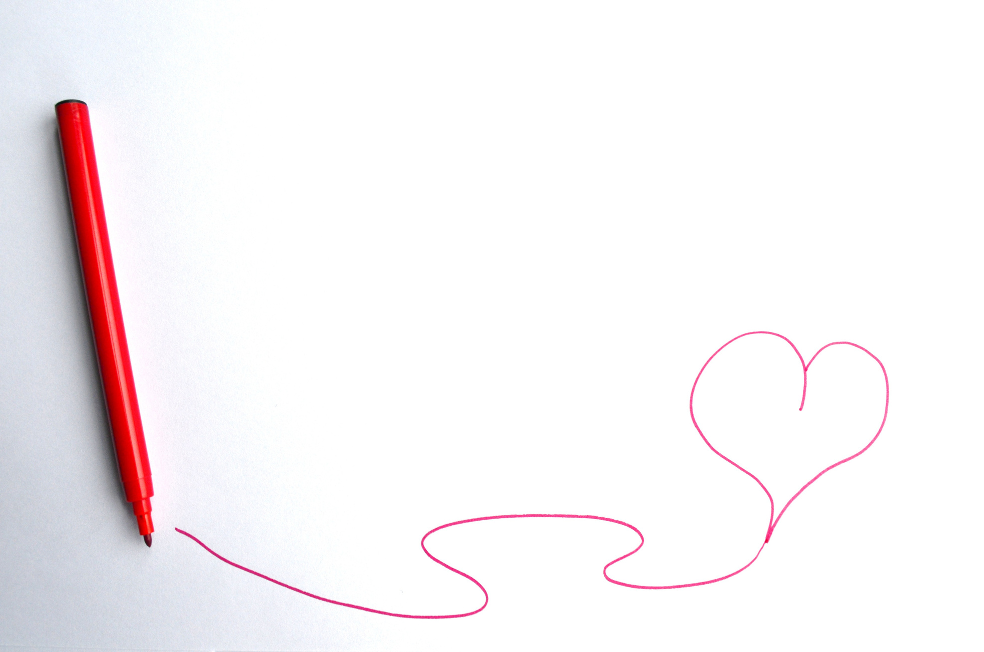 Red Pen Drawing Heart on White Background
